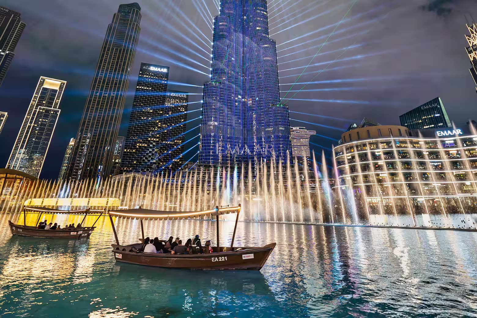 The Dubai Fountain and Burj Khalifa at night, an abra passing in front