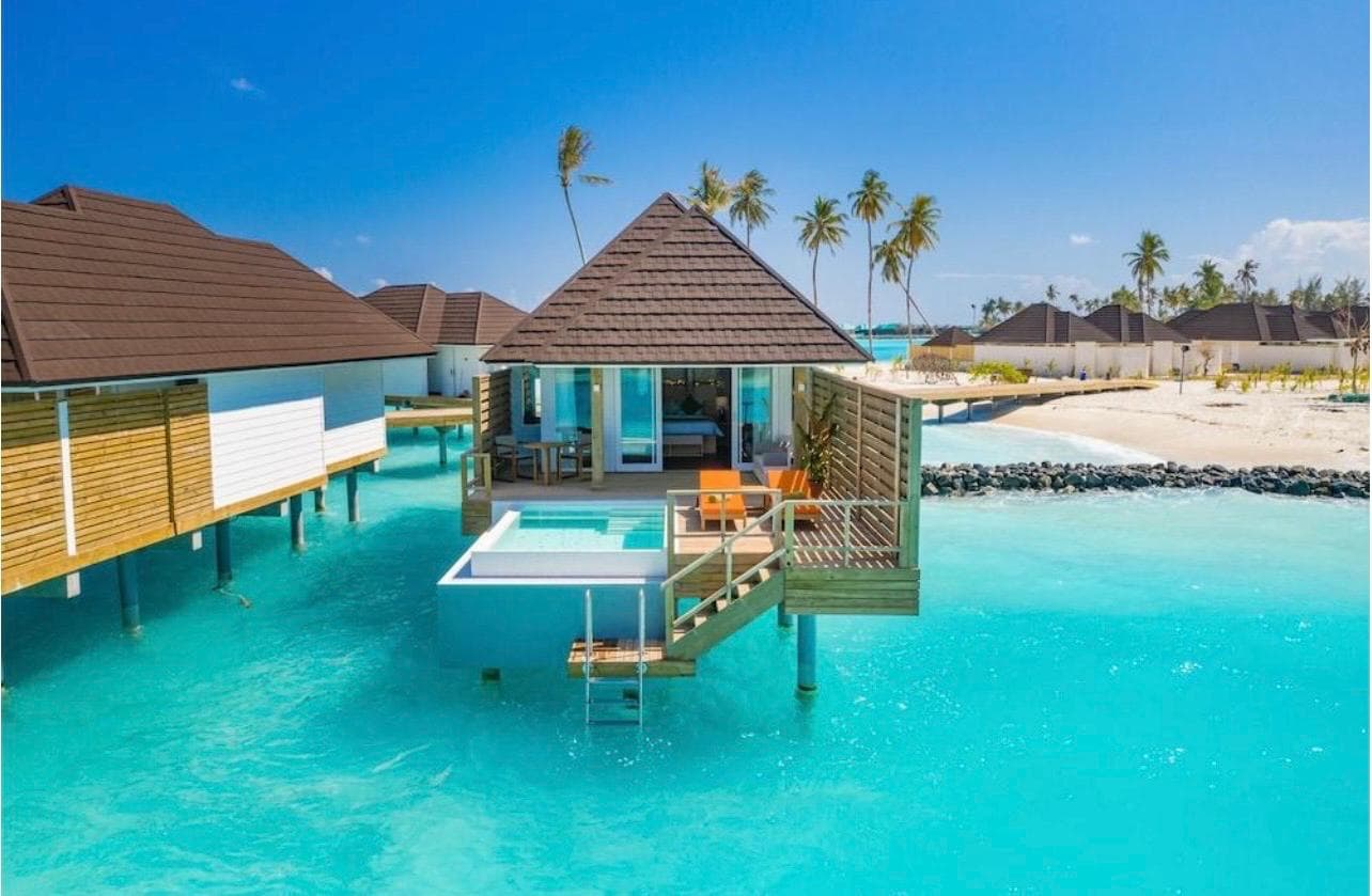 An overwater villa with a private plunge pool above a turquoise Maldivian lagoon